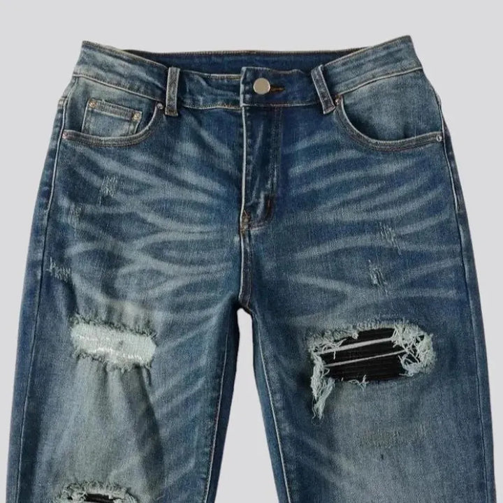 Medium-wash men's black-patch jeans