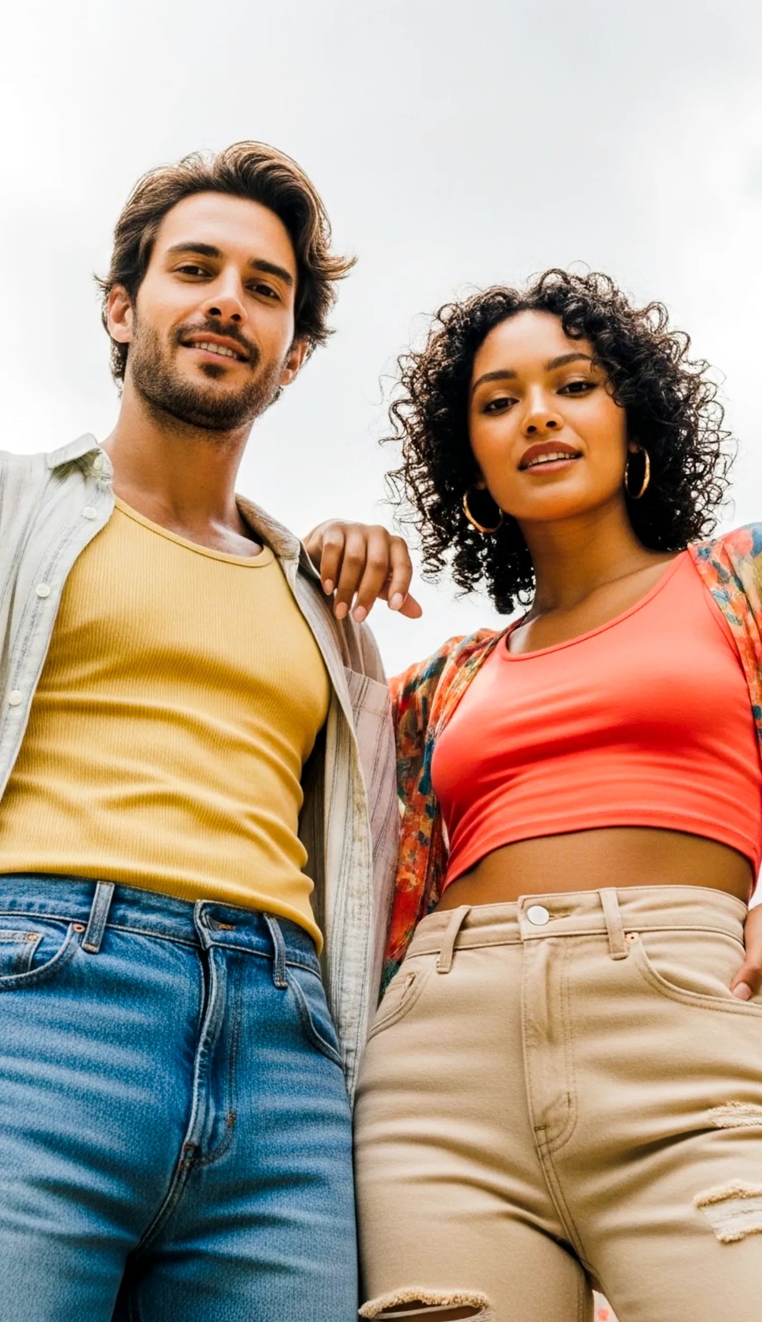 Two people standing close together outdoors with a clear sky background